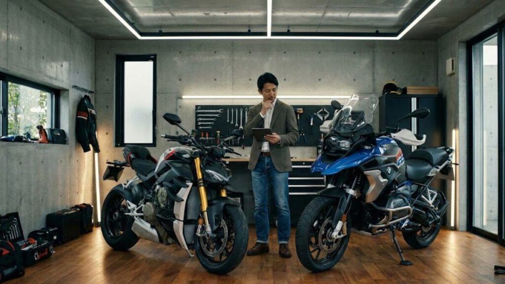 ガレージで2台のオートバイを前に、タブレットを手に持ちながら売却を検討する男性。バイク王とバイクランドを比較して、後悔のない選択をしようとしている様子。