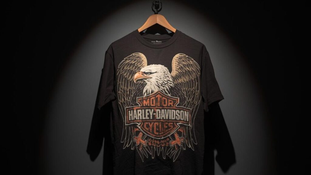 3Dエンブレムによる立体的なプリントが芸術的な、極めて希少なハーレーダビッドソンの古着。コレクター垂涎の逸品を、美術館のような厳かなライティングで捉えた画像。