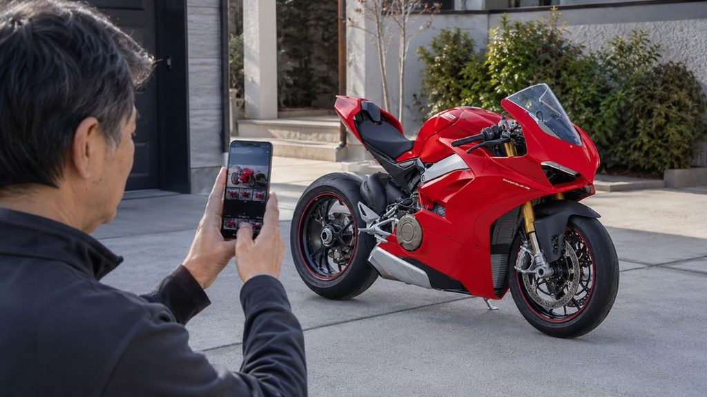オンライン一括査定用に大型バイクをスマートフォンで撮影する50代男性