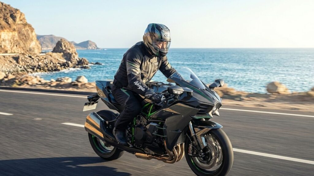 保安部品を備えたバイクで海沿いの公道をツーリングするライダーの姿です。H2Rが公道を走れないのとは対照的に、合法的に公道を楽しめるモデルを表しています。