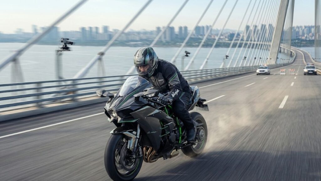 閉鎖された橋の上を猛スピードで駆け抜けるライダーの姿です。H2Rが公道を走れない理由となる、特殊条件で語られる最高速度の世界観を表しています。