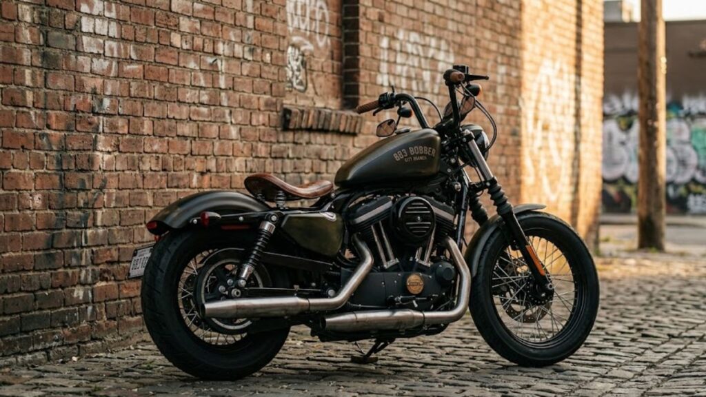 無骨なボバースタイルに仕上げられたハーレー 883のカスタム。都会的な壁を背景に、特徴的な低いシルエットを強調した一枚です。