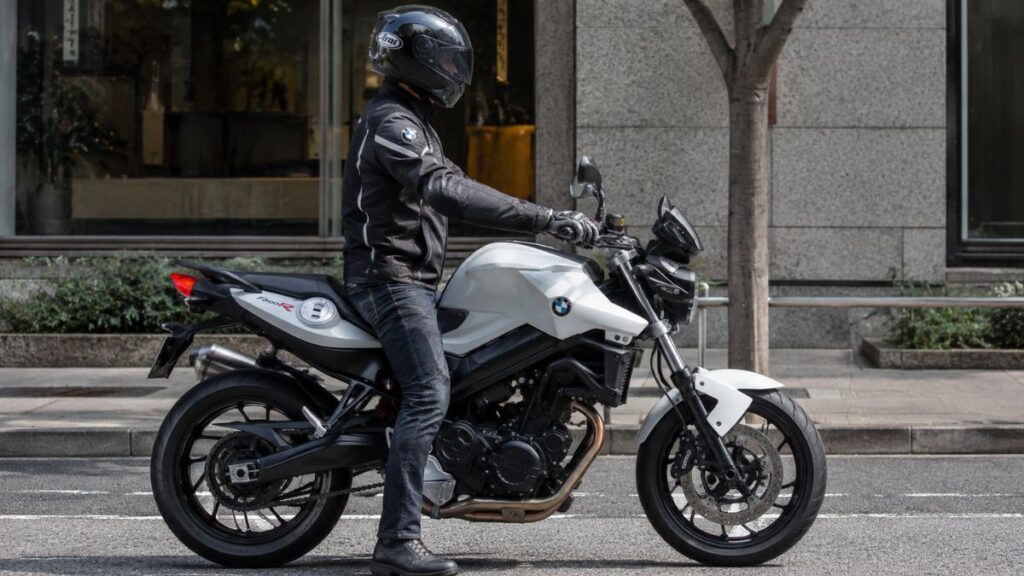 シート高が低く、両足がしっかりと地面に着いているBMW F800Rの足つき性を確認するヘルメット着用の日本人ライダー