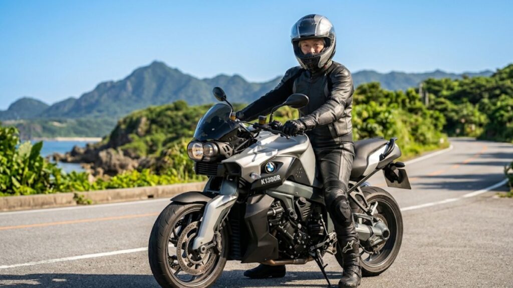 ヘルメットと厚手のライディングパンツを着用し、BMW K1300Rに跨がって足つきと乗車姿勢を確認する50代の日本人男性