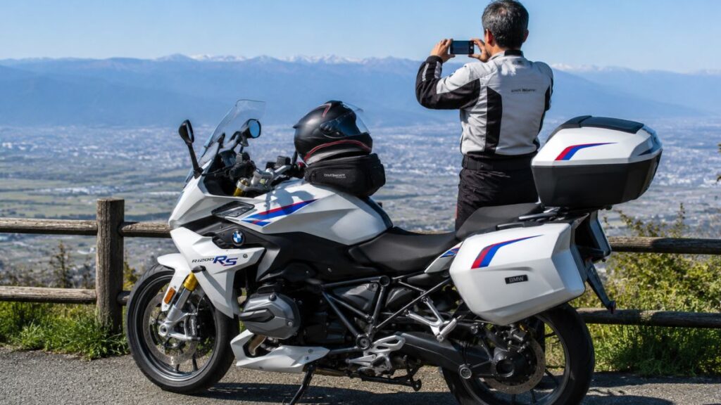 フルパニア装備で絶景ポイントに停まるBMW R1200RSと、風景を撮影する日本人ライダー