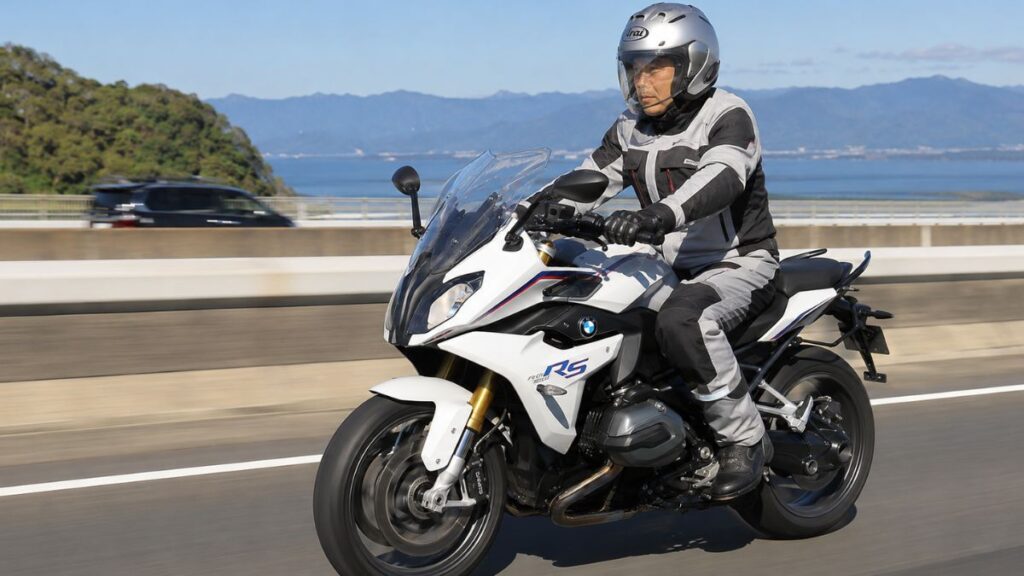 高速道路を安定して快適にクルージングする、ヘルメットを着用した日本人ライダーとR1200RS