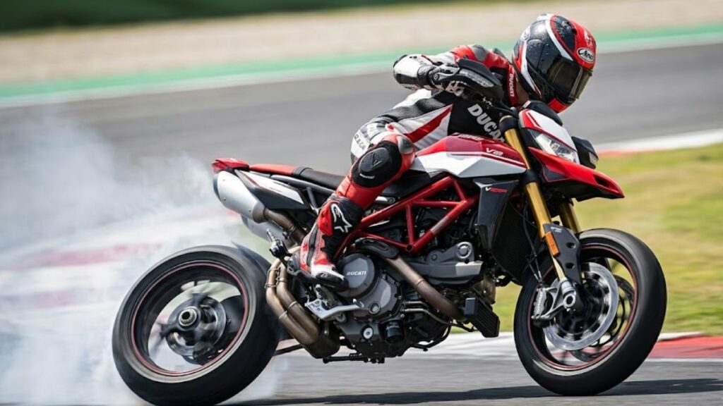 サーキットのヘアピンを深いバンク角でコーナリングする、ドゥカティ ハイパーモタードV2 SPと日本人ライダー。